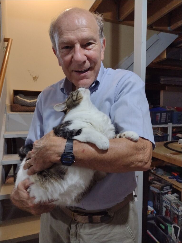 Don Burrier holding Pretty cat, a white gray and tan cat.